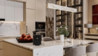 Đảo bếp bằng đá marble nguyên khối đóng vai trò là trung tâm kết nối giữa khu vực nấu nướng và bàn ăn