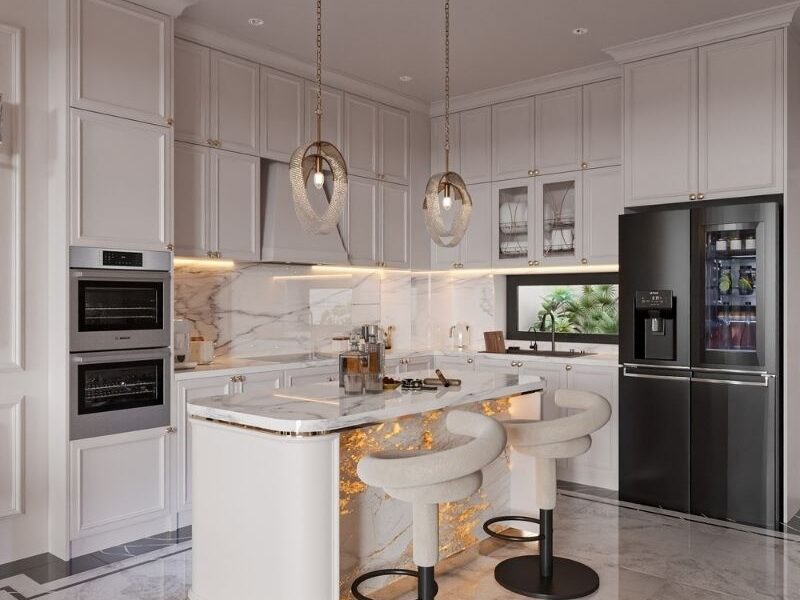 Hệ tủ bếp màu kem bao quanh với thiết kế kịch trần giúp tối ưu không gian lưu trữ và tích hợp các thiết bị điện tử hiện đại